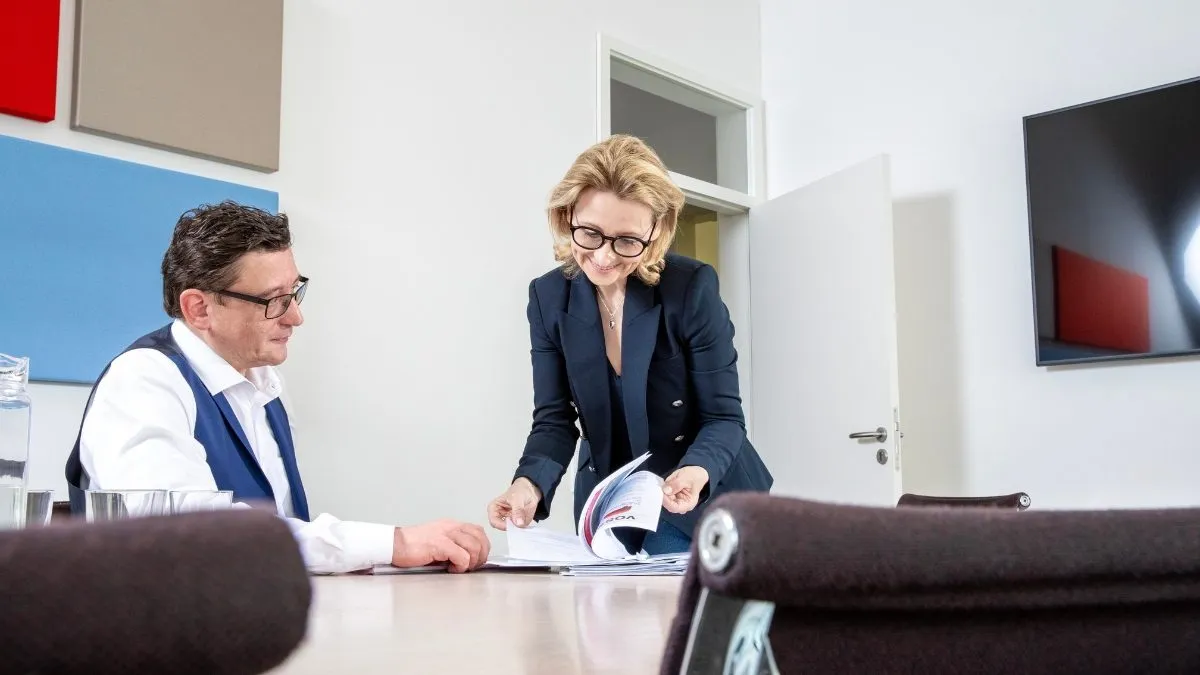 Frau mit Brille schaut auf ein Dokument