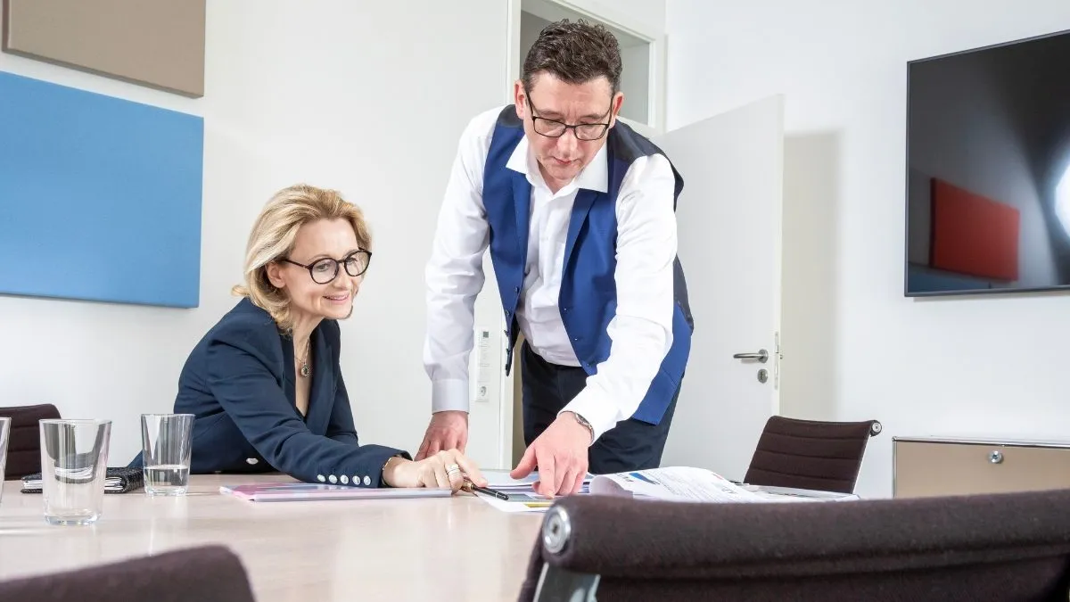 Mann im Anzug prüft ein Dokument im Büro