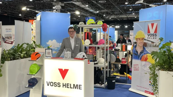Mann am Messestand von Voss Helme auf der PSI-Messe mit Werbeartikeln