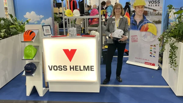 Frau am Messestand von Voss Helme auf der PSI-Messe im Gespräch